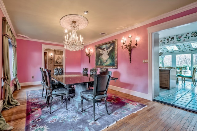 dining area with ornamental molding, a chandelier, and light wood-type flooring