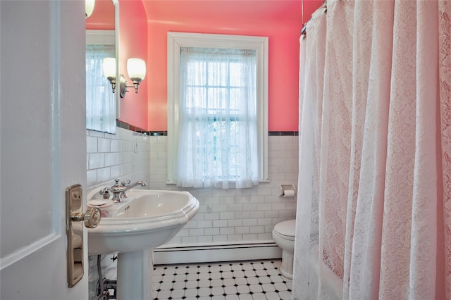 bathroom featuring toilet, tile walls, curtained shower, tile patterned flooring, and a baseboard heating unit