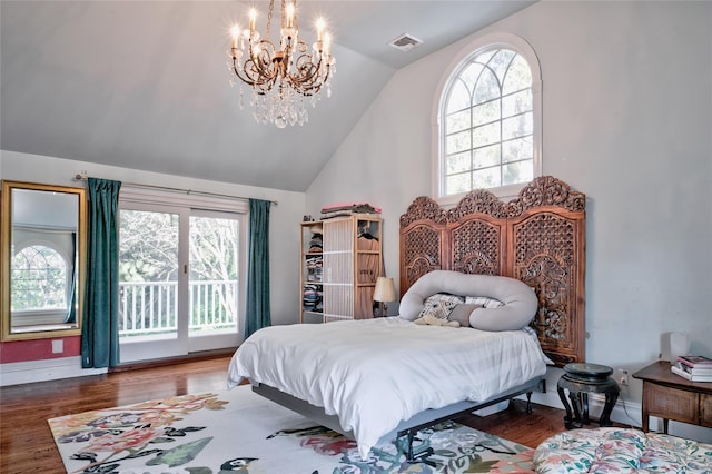 bedroom featuring dark hardwood / wood-style floors, access to exterior, multiple windows, and a notable chandelier