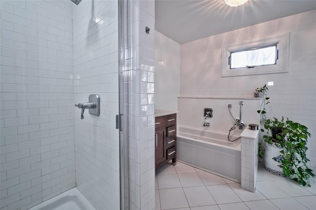 bathroom with tile walls, tile patterned floors, and independent shower and bath