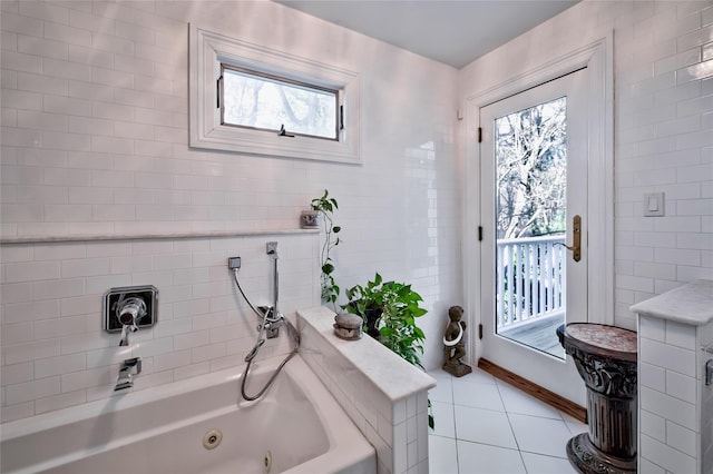 bathroom with tile walls, a tub to relax in, and tile patterned floors