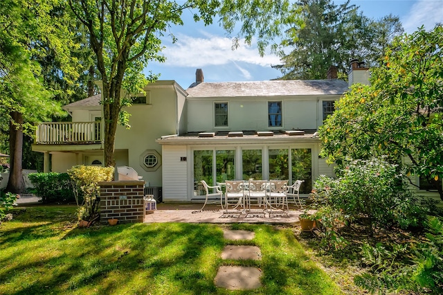 back of house featuring a balcony, a yard, and a patio area