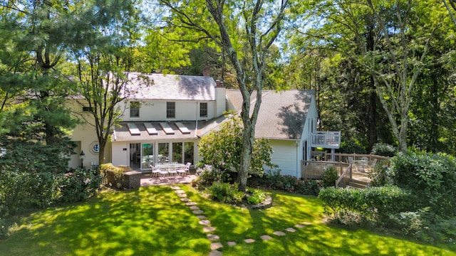 rear view of property with a lawn, a patio, and a deck