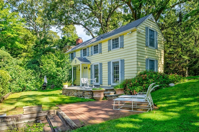 rear view of house featuring a yard and a patio area