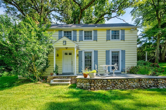 colonial house with a patio and a front yard