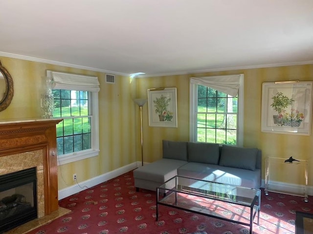 living room featuring a fireplace, ornamental molding, and carpet