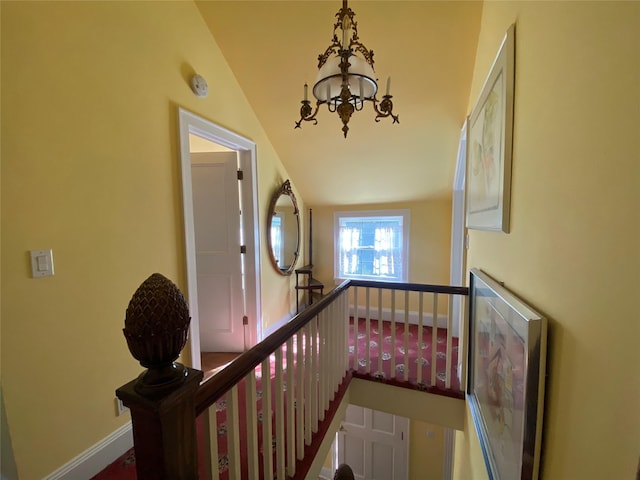 hallway featuring vaulted ceiling and a chandelier