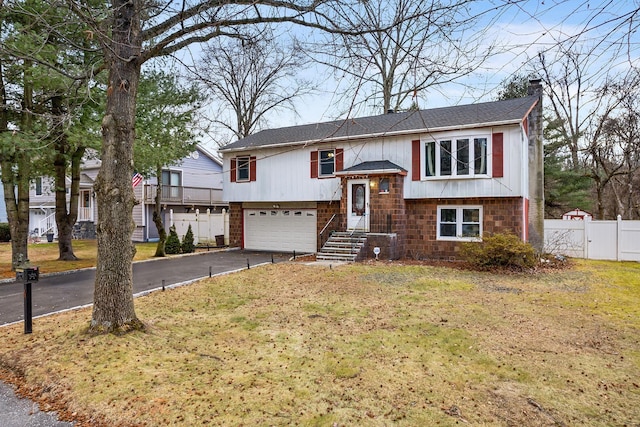 raised ranch with a garage and a front yard