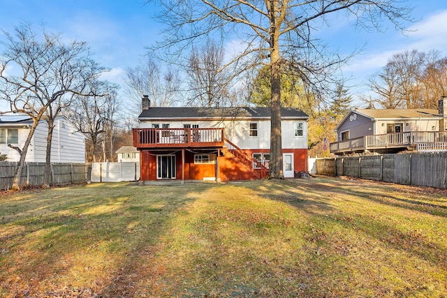 back of property with a wooden deck and a yard