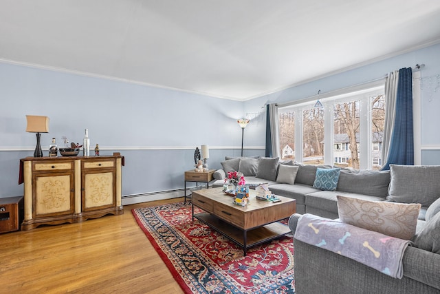 living room featuring hardwood / wood-style flooring, a baseboard radiator, and crown molding