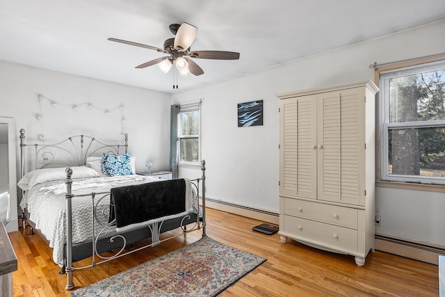 bedroom featuring ceiling fan, a baseboard radiator, and light hardwood / wood-style flooring