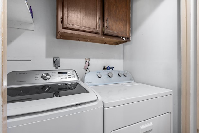 laundry room featuring washing machine and dryer and cabinets