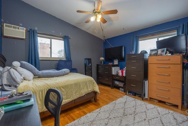 75 Tennyson Dr, Nanuet, NY 10954 - bedroom with ceiling fan, vaulted ceiling, a wall unit AC, and hardwood / wood-style flooring