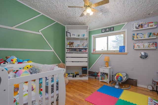 75 Tennyson Dr, Nanuet, NY 10954 - bedroom with ceiling fan, wood-type flooring, and a nursery area