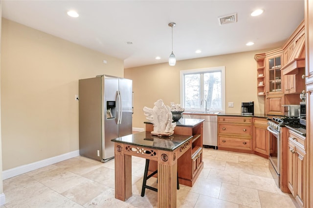 kitchen with appliances with stainless steel finishes, a center island, decorative light fixtures, sink, and a breakfast bar