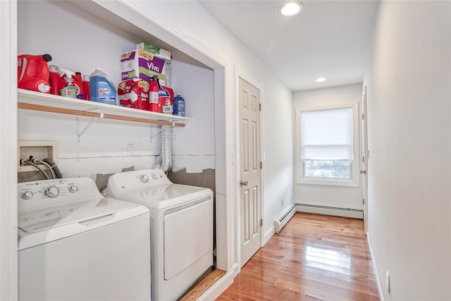 laundry area with a baseboard heating unit, washer and clothes dryer, and light wood-type flooring