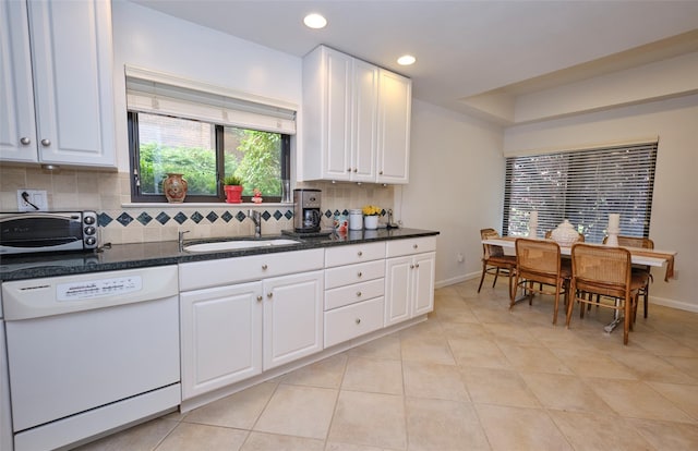 kitchen featuring tasteful backsplash, white dishwasher, sink, light tile patterned floors, and white cabinets