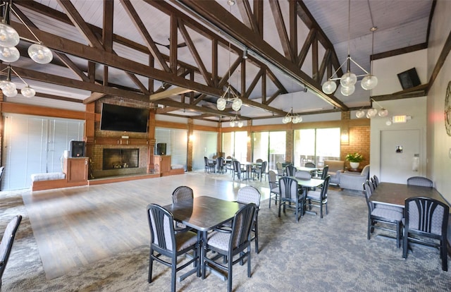 dining room featuring beamed ceiling, a fireplace, and high vaulted ceiling