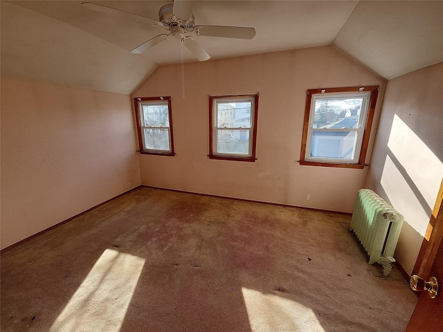 additional living space featuring ceiling fan, radiator heating unit, light carpet, and vaulted ceiling