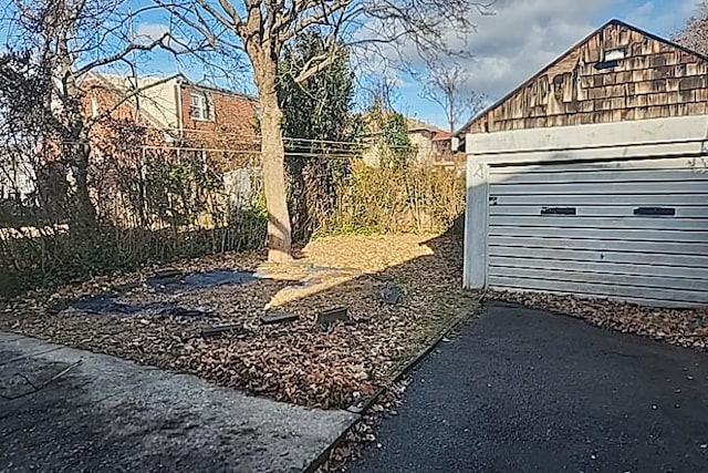 view of yard with a garage and an outbuilding