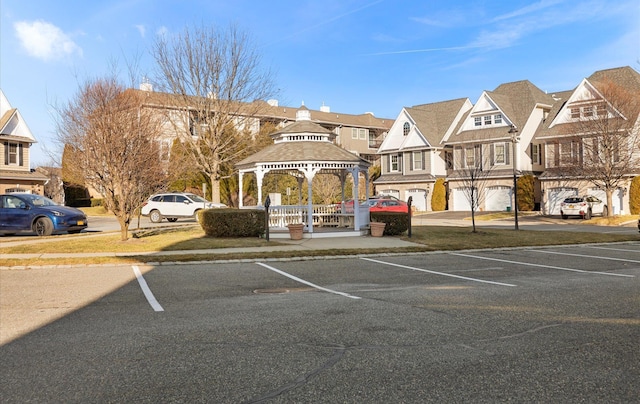 view of parking with a garage and a gazebo