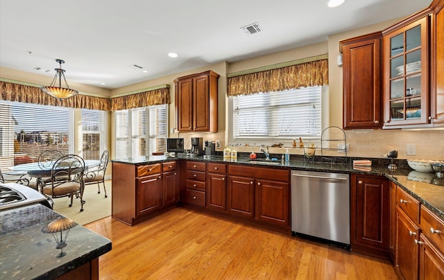 kitchen with dishwasher, dark stone countertops, light hardwood / wood-style floors, pendant lighting, and sink