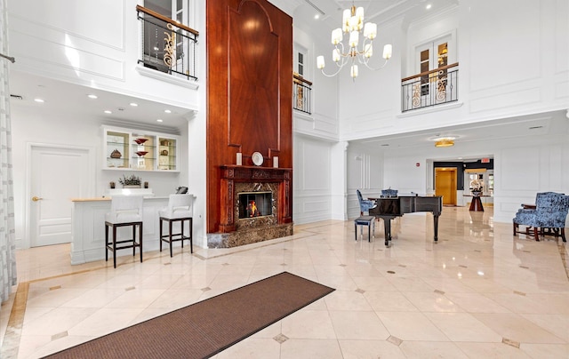 interior space featuring a chandelier, a high end fireplace, a towering ceiling, and light tile patterned flooring