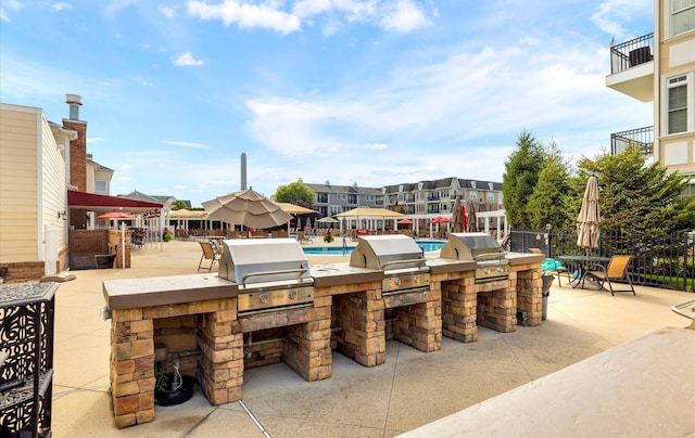 view of patio with area for grilling, exterior kitchen, and an outdoor bar