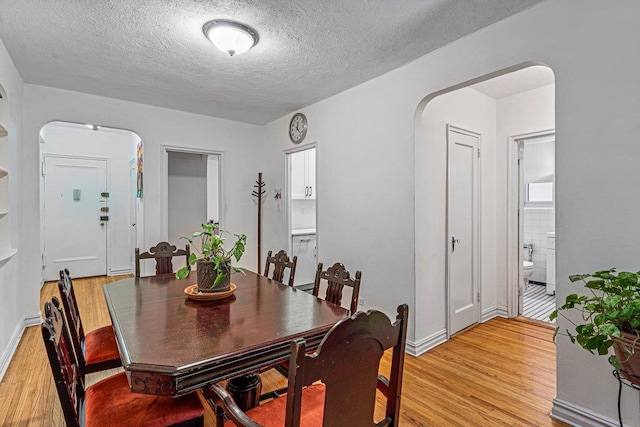 dining room featuring a textured ceiling and light hardwood / wood-style flooring