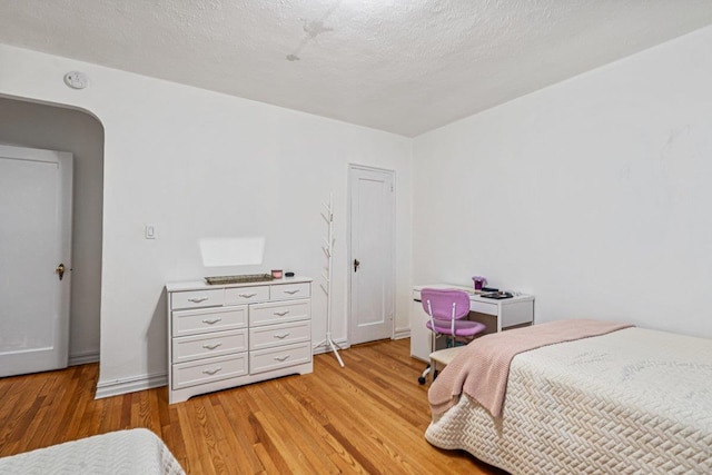 bedroom with light hardwood / wood-style flooring and a textured ceiling