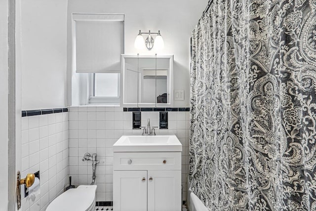 bathroom featuring curtained shower, vanity, tile walls, and toilet