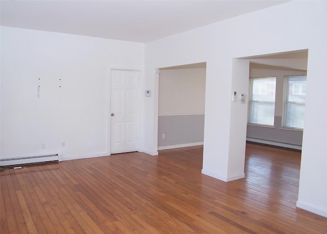 spare room with dark hardwood / wood-style flooring and a baseboard radiator