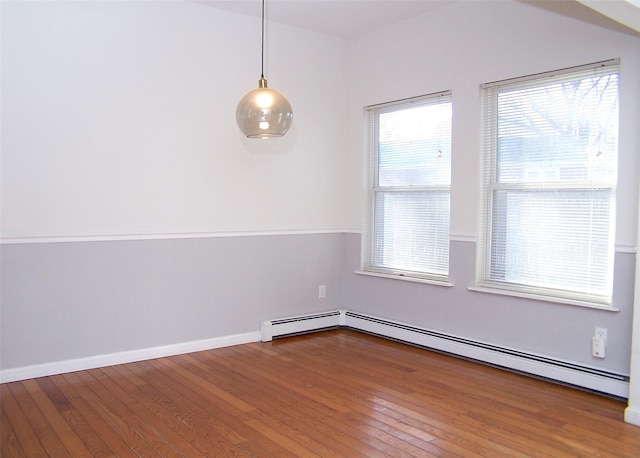 unfurnished room featuring wood-type flooring and a baseboard radiator