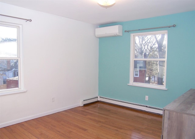 empty room featuring a wall mounted air conditioner, a baseboard radiator, and wood-type flooring