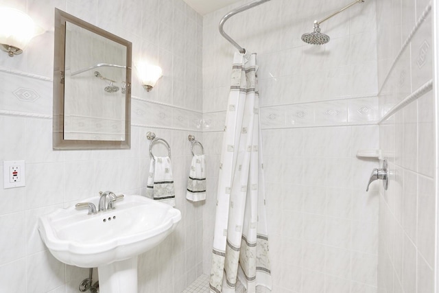 bathroom with a shower with curtain, tile walls, and sink