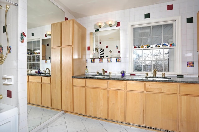 interior space featuring sink, light tile patterned floors, and dark stone counters