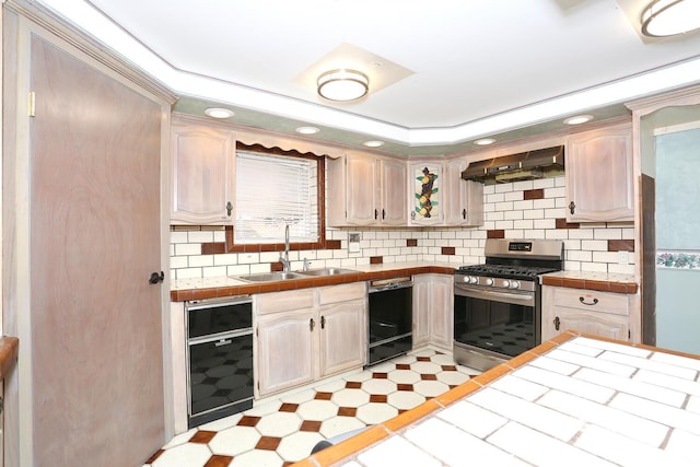 kitchen featuring sink, dishwasher, tile countertops, gas range, and exhaust hood