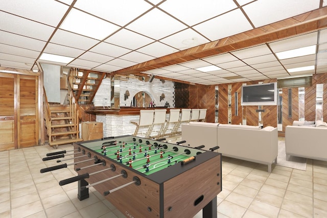 game room with wood walls and a paneled ceiling