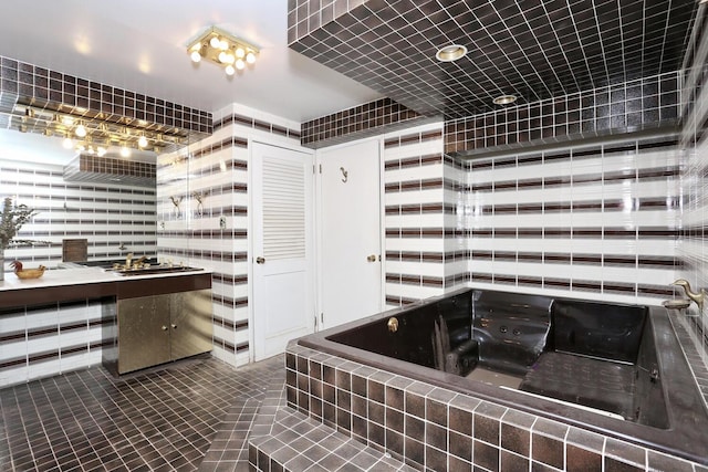 bathroom with tile patterned flooring and tiled tub