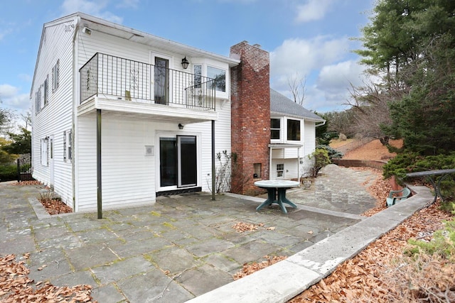 back of house featuring a balcony and a patio