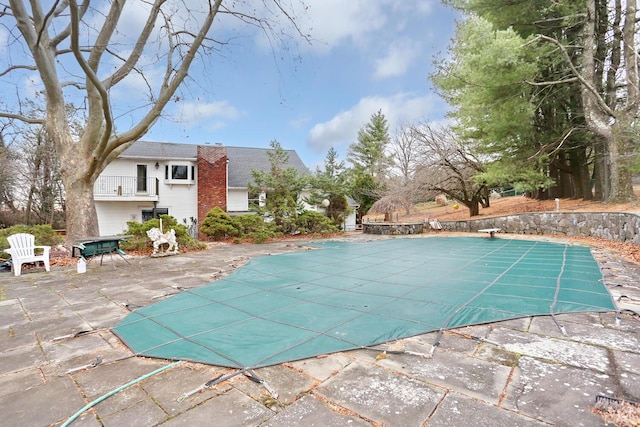 view of swimming pool featuring a diving board and a patio area