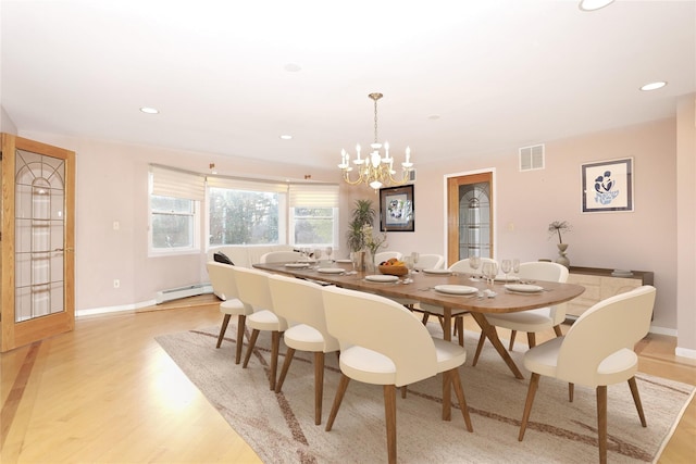 dining area featuring light hardwood / wood-style floors, a baseboard radiator, and a chandelier