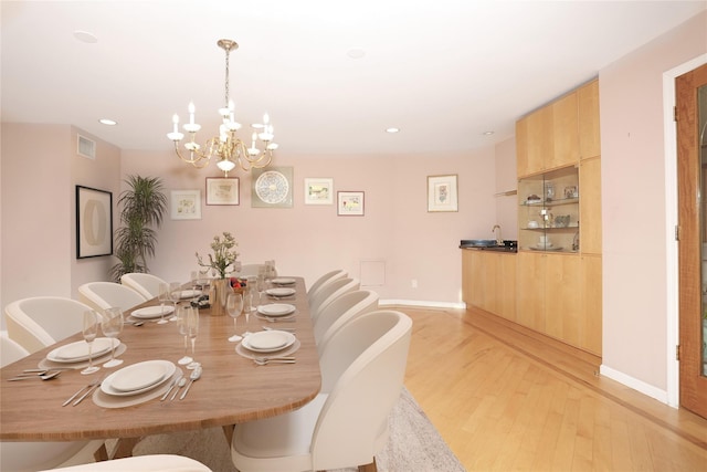 dining area featuring light hardwood / wood-style flooring and an inviting chandelier