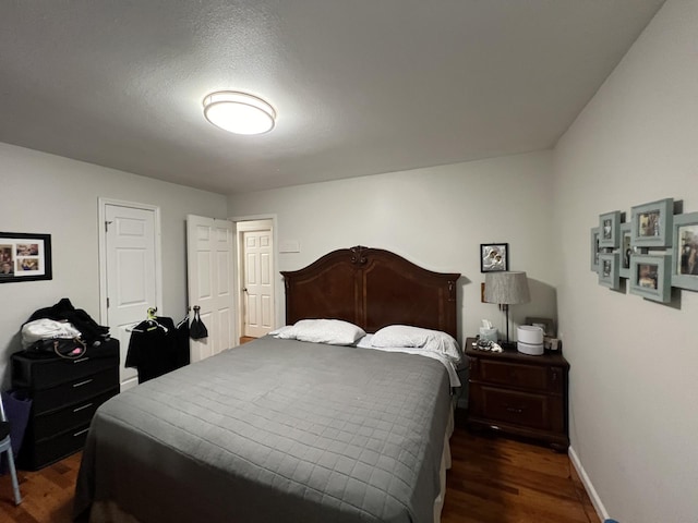 bedroom featuring a textured ceiling and dark hardwood / wood-style floors