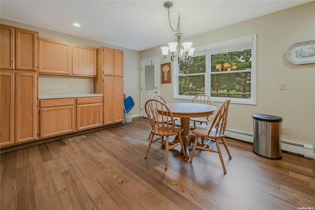 dining space featuring a chandelier, wood-type flooring, and a baseboard radiator