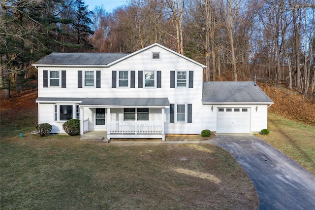 view of front of house with a front lawn, covered porch, and a garage