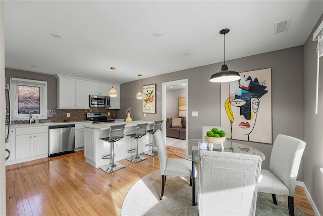 dining area with light hardwood / wood-style flooring and sink