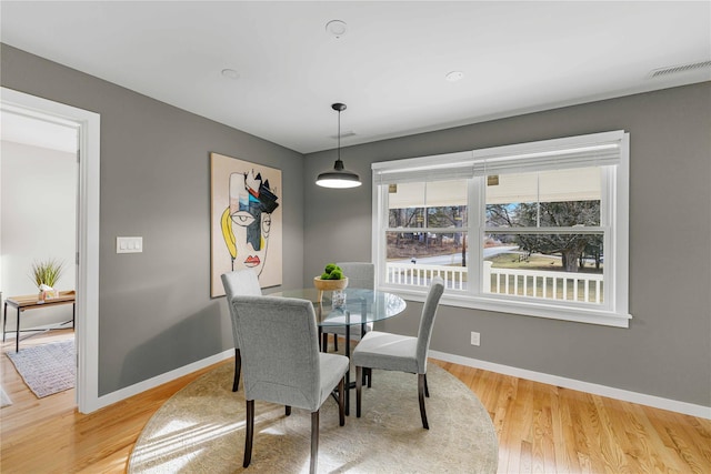 dining space with wood-type flooring