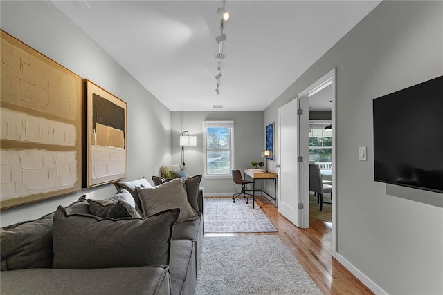 living room with track lighting and light hardwood / wood-style floors