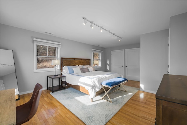 bedroom with multiple windows and light hardwood / wood-style floors